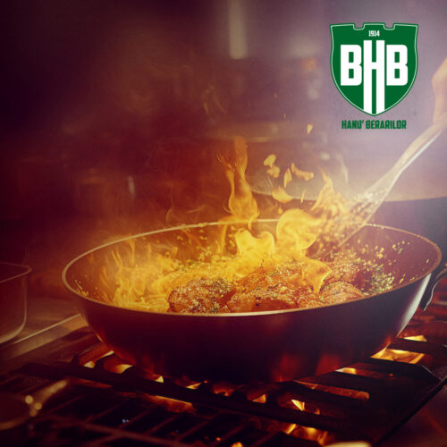 Fiery skillet cooking on a gas stove with a bright BHB logo in the top-right corner, promoting Hanu Berarilor.